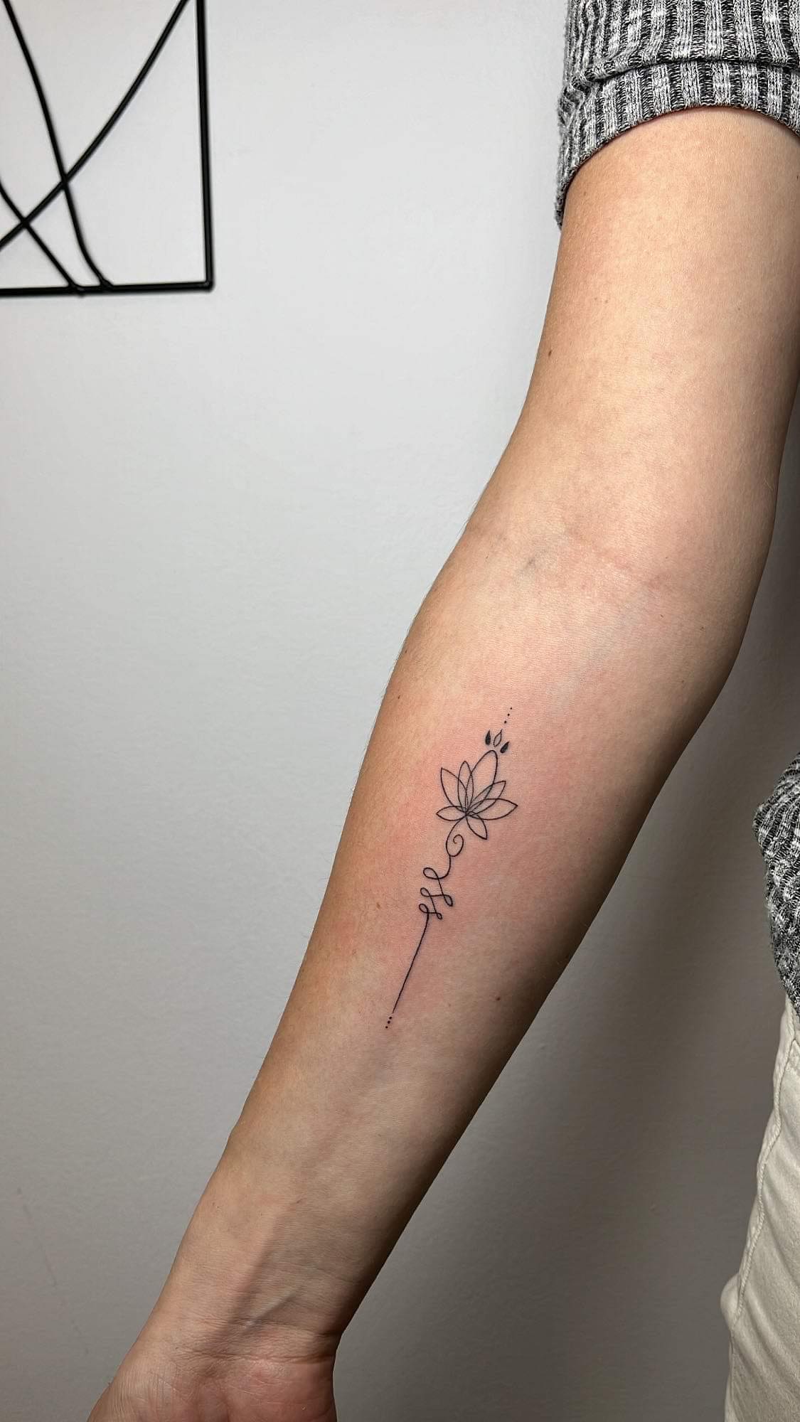 damski delikatny tatuaż kwiatka na przedramieniu